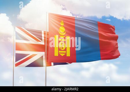 Sonniger blauer Himmel und Flaggen der mongolei und des vereinigten Königreichs Stockfoto