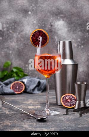 Aperol Spritz Cocktail in großem Weinglas mit blutigen Orangen. Stockfoto