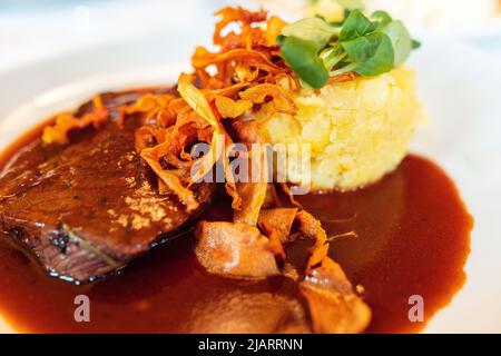 Fleisch in Tomate und Weinsauce mit Kartoffeln. Fleisch Rindfleisch geschmort in Burgunder Wein Boeuf Bourguignon, Burgunderfleisch mit Kartoffelpüree Stockfoto