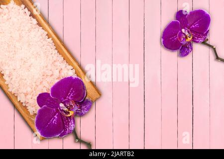 Meersalz mit Schale in Schale mit violetten Orchideen auf rosa Brettern. Spa-Konzept Stockfoto