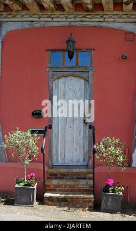 Architektonische Details einer Eingangstür mit Stufen von der Straße eines mittelalterlichen Fachwerkhauses in Lavenham, Suffolk, England, Großbritannien. Stockfoto