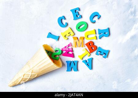 Waffelkegel und bunte Holzbuchstaben in Eisform mit Schriftzug. Kreatives Sommerkonzept. Stockfoto