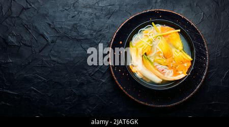 Suppe mit Reisnudeln und Kürbisblüten.Asiatische vegane Suppe.Platz kopieren Stockfoto