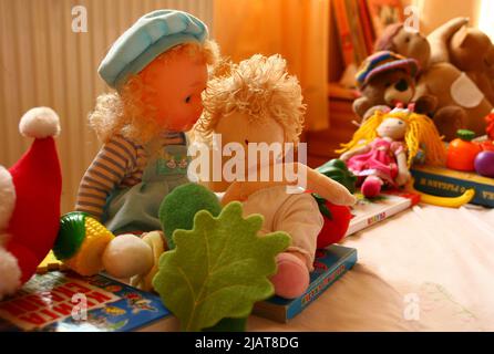 Vintage Kinder Zimmer Objekte. Das Kind hat Puppen, Plüschtiere, Kinderbücher, Teddybär, Textilgemüse, Pilz auf dem Sofa im regulären ch Stockfoto