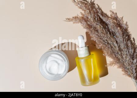 Anti-Aging Retinol Gesichtsserum in einer Glasflasche und Gesichtscreme auf beigem Hintergrund mit Kopierraum. Natural Organic Cosmetic Beauty Konzept Stockfoto