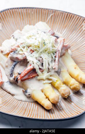 Weißer Aparagus mit Pilzsauce und Schinken, serviert mit Blauschimmelkäse Stockfoto