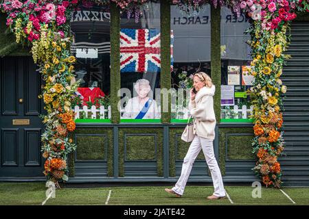 London, 1. Juni 2022. Ein Fußgänger geht am Porträt Ihrer Majestät Königin Elizabeth vorbei, das auf dem Fenster eines Restaurants im Dorf Wimbledon zu sehen ist, während sich das Vereinigte Königreich auf das Platin-Jubiläum vom 2-5. Juni vorbereitet, um Königin Elizabeth 70 Jahre als britische Monarchin zu feiern. Kredit. amer Ghazzal/Alamy Live Nachrichten Stockfoto