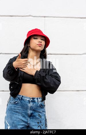 Junge lateinische Frau Hip-Hop tanzen auf der Straße mit einem roten Hut, Panama, Mittelamerika - Stock Foto Stockfoto