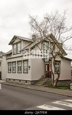 Reykjavik, Island, 25. April 2022: Relativ bescheidenes Haus in der Altstadt mit einem großen Baum, für isländische Verhältnisse, im Garten Stockfoto