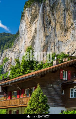 Typisches Schweizer Berghaus mit Staubbach-Wasserfall, Lauterbrunnen, Kanton Bern, Schweiz Stockfoto