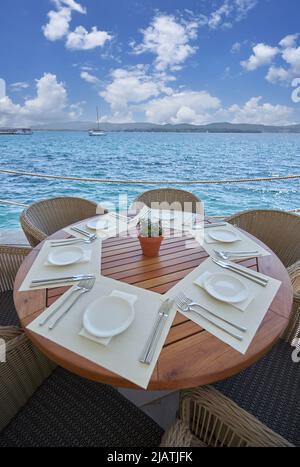 Leerer runder Tisch aus Holz in einem Restaurant mit Meerblick Stockfoto