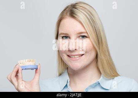 Junge Zahntechnikerin arbeitet an Prothesenteilen in einem Zahnlabor Stockfoto