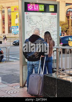 Ein paar Reisende vor der U-Bahn-Karte von Barcelona, die auf die Parallelstation zeigt. Barcelona, Katalonien, Spanien. Stockfoto
