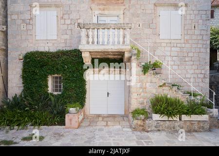 Altes Steinhaus mit Efeu-Pflanze an der Wand Stockfoto