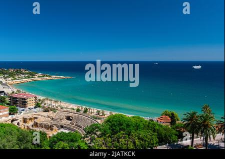 28. Mai 2022, Tarragona, Katalonien, Spanien: Blick auf das Amphitheater von Tarragona am Meer mit dem Strand und türkisfarbenem Meer gebaut. Gebaut in der II? Jahrhundert während der Herrschaft von Hadrian, ist der Circus Antico von Tarragona Teil eines römischen archäologischen Komplexes, der von den lokalen Behörden auf touristischen Wert gesetzt wurde. t ist in der UNESCO-Liste des Weltkulturerbes enthalten. Seit 1998, ''tarraco Viva'' ist ein Fest, das die römische Kultur von Tarragona im Mai präsentiert. Es ist ein großer Gewinn, um Kreuzfahrtkunden anzuziehen.seit 2021 hat der Hafen von Tarragona eine Investition angekündigt, um zu erhöhen Stockfoto