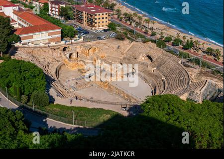 Tarragona, Katalonien, Spanien. 28.. Mai 2022. Luftaufnahme des Amphitheaters von Tarragona, das am Meer erbaut wurde. Gebaut in der II? Jahrhundert während der Herrschaft von Hadrian, ist der Circus Antico von Tarragona Teil eines römischen archäologischen Komplexes, der von den lokalen Behörden auf touristischen Wert gesetzt wurde. t ist in der UNESCO-Liste des Weltkulturerbes enthalten. Seit 1998, ''tarraco Viva'' ist ein Fest, das die römische Kultur von Tarragona im Mai präsentiert. Es ist ein großer Gewinn, um Kreuzfahrtkunden anzuziehen.seit 2021 hat der Hafen von Tarragona eine Investition angekündigt, um die Kapazität für Kreuzschiffe zu erhöhen Stockfoto