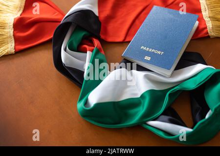 Reisepass und eine Flagge der Vereinigten Arabischen Emirate auf einem hölzernen Hintergrund. Reisekonzept. Stockfoto