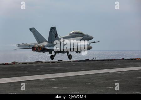 PHILIPPINISCHE SEE (28. Mai 2022) eine F/A-18F Super Hornet, die den 'Black Aces' des Strike Fighter Squadron (VFA) 41 zugewiesen wurde, startet vom Flugdeck des Nimitz-Klasse-Flugzeugträgers USS Abraham Lincoln (CVN 72). Die Abraham Lincoln Strike Group befindet sich im geplanten Einsatzgebiet der US-Flotte für 7., um die Interoperabilität durch Allianzen und Partnerschaften zu verbessern und gleichzeitig als reaktionsfähige Truppe zur Unterstützung einer freien und offenen Region im Indo-Pazifik-Raum zu dienen. (USA Navy Foto von Mass Communication Specialist 3. Class Javier Reyes) Stockfoto