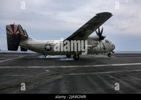 PHILIPPINE SEA (28. Mai 2022) Ein C-2A Greyhound, der den „Anbietern“ des Fleet Logistics Support Squadron (VRC) 30 zugewiesen wurde, landet auf dem Flugdeck des Flugzeugträgers USS Abraham Lincoln (CVN 72) der Nimitz-Klasse verhaftet. Die Abraham Lincoln Strike Group befindet sich im geplanten Einsatzgebiet der US-Flotte für 7., um die Interoperabilität durch Allianzen und Partnerschaften zu verbessern und gleichzeitig als reaktionsfähige Truppe zur Unterstützung einer freien und offenen Region im Indo-Pazifik-Raum zu dienen. (USA Navy Foto von Mass Communication Specialist 3. Class Javier Reyes) Stockfoto