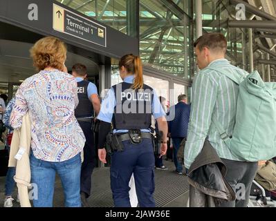 Hamburg, Deutschland. 01.. Juni 2022. Passagiere und Polizisten betreten den Flughafen. Die Bundespolizei hat den Sicherheitsbereich dort geräumt. "Aufgrund polizeilicher Ermittlungen wurde der zentrale Kontrollpunkt geräumt", sagte eine Sprecherin der Bundespolizei. Im Moment konnten keine Flugzeuge starten. Kredit: Marcus Brandt/dpa/Alamy Live Nachrichten Stockfoto