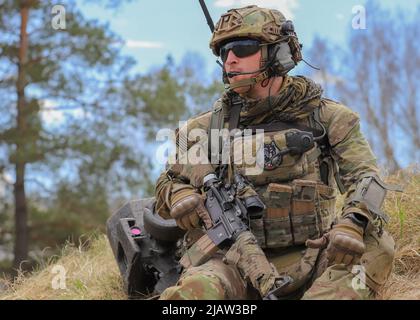 Bemowo Pikie Training Area, Orzysz, Polen - Sgt. Nile Adams, ein Soldat der Bravo Company, 185. Infantry Regiment, California Army National Guard, kommunizierte mit seinen Soldaten während des letzten Trainingstages der Übung Thunderbolt Focus 2022, 27. April. US-Soldaten unter anderem aus verbündeten Nationen arbeiteten in dynamischen Teams gegen Taktiken, Techniken und Verfahren zusammen, die von feindlichen Truppen verwendet wurden und es den Schlachtgruppen ermöglichten, alle Kampfkünste, Interoperabilität und Kontrollfähigkeiten zu üben, zu verfeinern und zu validieren. (USA Armee-Foto von SPC. Devin Klekan/Freigegeben) Stockfoto