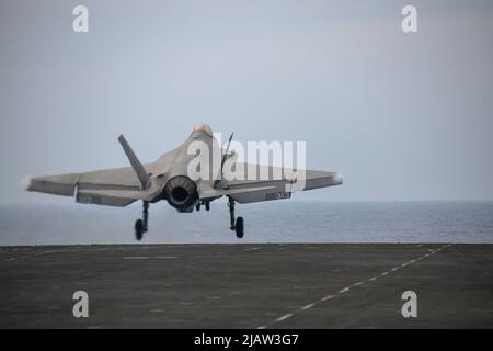 PHILIPPINISCHE SEE (28. Mai 2022) eine F-35C Lightning II, die den "Black Knights" of Marine Fighter Attack Squadron (VMFA) 314 zugewiesen wurde, startet vom Flugdeck des Nimitz-Klasse-Flugzeugträgers USS Abraham Lincoln (CVN 72). Die Abraham Lincoln Strike Group befindet sich im geplanten Einsatzgebiet der US-Flotte für 7., um die Interoperabilität durch Allianzen und Partnerschaften zu verbessern und gleichzeitig als reaktionsfähige Truppe zur Unterstützung einer freien und offenen Region im Indo-Pazifik-Raum zu dienen. (USA Navy Foto von Mass Communication Specialist 3. Class Javier Reyes) Stockfoto