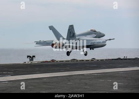 PHILIPPINISCHE SEE (28. Mai 2022) eine F/A-18E Super Hornet, die den "Tophoattern" des Strike Fighter Squadron (VFA) 14 zugewiesen wurde, startet vom Flugdeck des Nimitz-Klasse-Flugzeugträgers USS Abraham Lincoln (CVN 72). Die Abraham Lincoln Strike Group befindet sich im geplanten Einsatzgebiet der US-Flotte für 7., um die Interoperabilität durch Allianzen und Partnerschaften zu verbessern und gleichzeitig als reaktionsfähige Truppe zur Unterstützung einer freien und offenen Region im Indo-Pazifik-Raum zu dienen. (USA Navy Foto von Mass Communication Specialist 3. Class Javier Reyes) Stockfoto