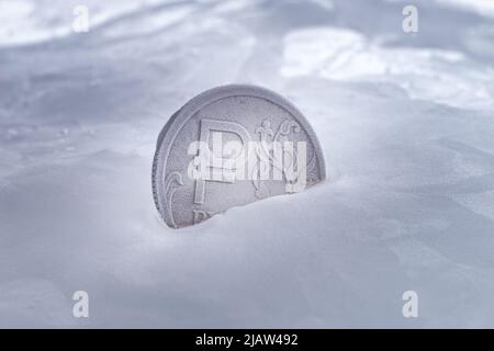 Gefrorene silberfarbene Münze mit einem russischen Rubel-Symbol auf der Münze aus nächster Nähe. Sanktionen, Krise, Wechselkursschwankungen, Einfrieren und Aufheben des Einfrierens von Vermögenswerten Stockfoto