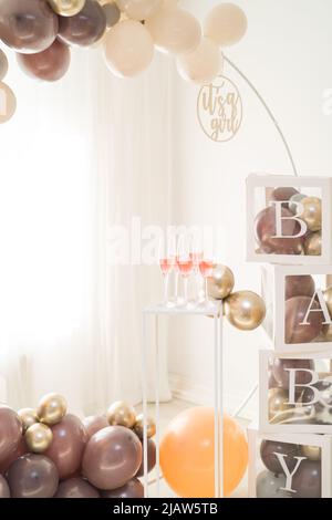 Rosafarbene Champagner-Drinks beim eleganten Baby-Shower-Brunch mit Ballonbogen Stockfoto