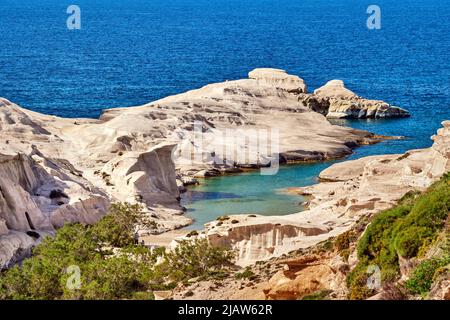 Berühmte weiße Felsen von Sarakiniko Strand, Ägäis, Insel Milos, Griechenland. Nur wenige Touristen verstecken sich im Schatten, leere Klippen, Sommersonne, klares Meerwasser Stockfoto