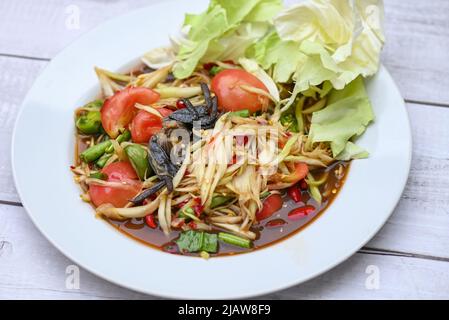 Thai Food Papaya Salat mit Kohlhof lange Bohnen auf weißem Teller, Papaya Salat mit Krabben und fermentierten Fisch Stockfoto