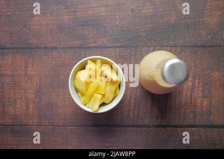 Mango Smoothie und frische Mango auf Holzhintergrund Stockfoto