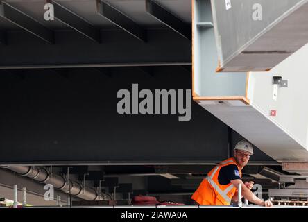 01. Juni 2022, Brandenburg, Werder (Havel): Ein Arbeiter folgt dem Anheben des Mittelabschnitts (r) einer Brücke über den Großen Zernsee. Die künftige Fahrrad- und Fußgängerbrücke zwischen Werder (Havel) und Potsdam soll am 2. Juni 2022 mit dem Anheben des letzten Stahlaufbaus und der Aussichtsplattform fertiggestellt werden. Foto: Soeren Sache/dpa Stockfoto