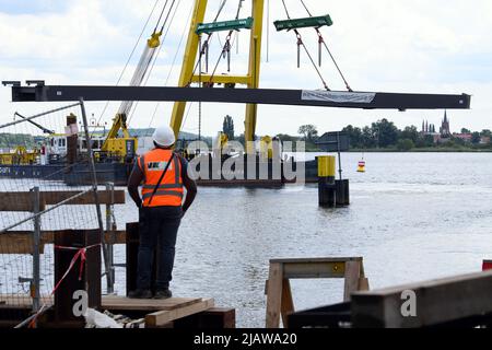 01. Juni 2022, Brandenburg, Werder (Havel): Der Mittelteil einer Brücke hängt vom Ausleger eines schwimmenden Krans, der auf dem Großen Zernsee unterwegs ist. Die künftige Fahrrad- und Fußgängerbrücke zwischen Werder (Havel) und Potsdam soll am 2. Juni 2022 fertiggestellt werden, wenn der letzte Stahlaufbau und die Aussichtsplattform angehoben werden. Foto: Soeren Sache/dpa Stockfoto