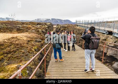 Das Gebiet von Þingvellir ist Teil einer Grabenzone, die durch Island verläuft und an der tektonischen Plattengrenze des Mittelatlantischen Rückens liegt. Die Verwerfungen und Risse in diesem Gebiet veranschaulichen die Zerstörung der Erdkruste. Ein guter Ort für ein Erinnerungsfoto in der engen Lücke zwischen Europa und Amerika. Þingvellir, Island Stockfoto