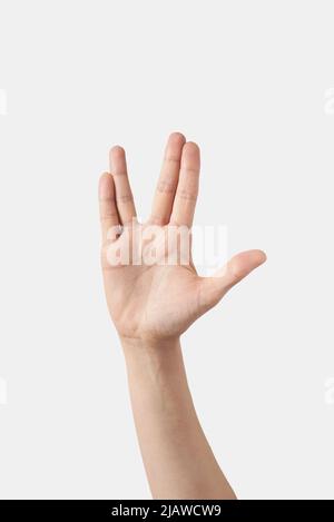 Weibliche Hand lustige Finger außerirdischen Frieden Geste der, Handfläche isoliert auf weißem Hintergrund. Stockfoto