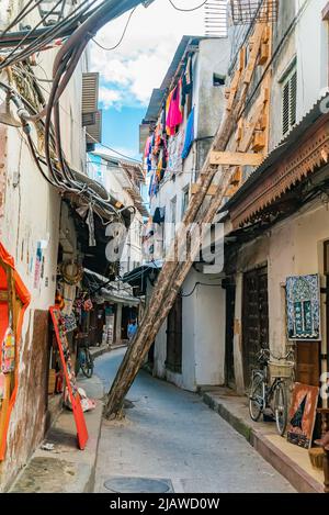 STONE TOWN, TANSANIA - 22. Dezember 2021: Enge Gassen und alte Häuser in Stone Town, Sansibar, Tansania Stockfoto