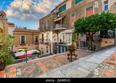 Schöne Altstadt von Taormina mit kleinen Straßen, Blumen. Architektur mit Bögen und alten Pflaster in Taormina. Bunte schmale Straße in der Altstadt o Stockfoto
