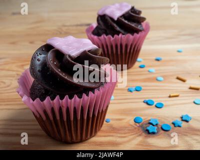 Cupcakes aus rotem Samt zum Valentinstag. Muffins für den Valentinstag auf einem hölzernen Hintergrund. Stockfoto