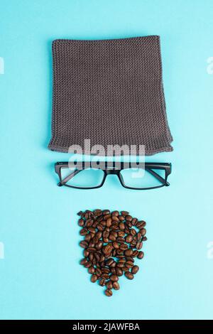 Menschliches Gesicht mit Wollhut, Brille und Kaffeebohnen als Bart, witziges minimalistisches Porträt, Öko-Freak-Lifestyle, Frühstück, Pause Stockfoto