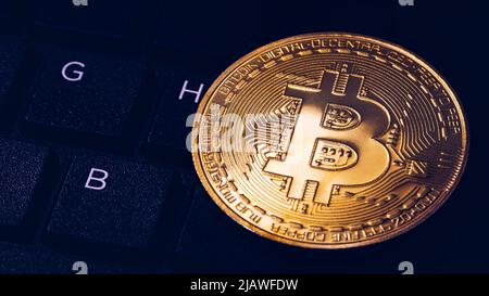 Bitcoin auf Computer Tastatur im Hintergrund, Symbol der elektronischen virtuelles Geld und Bergbau cryptocurrency Konzept. Münze crypto Währung bitcoin liegt auf Stockfoto