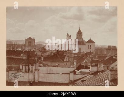 VILNIUS – ein allgemeiner Blick über die Dächer von Gebäuden zum Abwärtstor [Richtung Süden] – mit dominierenden Silhouetten der Kirchen St. Teresa von Ávila und Uniate Church of the Holy Trinity Fleury, Stanisław Filibert (1858 1915) Stockfoto