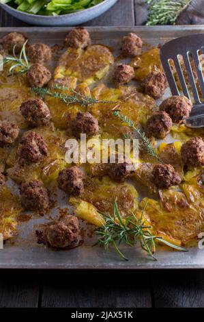 Ofenform mit Fleischbällchen und Kartoffeln auf einem Backblech Stockfoto