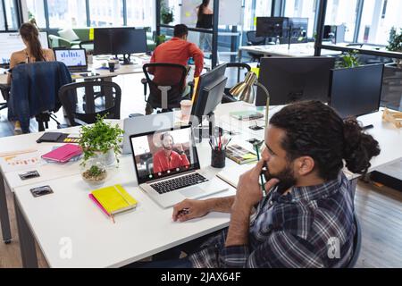 Biracial Geschäftsmann arbeitet mit biracial männlichen Kollegen auf Videoanruf im Büro. Unverändert, Geschäft, drahtlose Technologie, Videoanruf, Meeting, Arbeiten Stockfoto