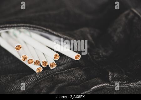 Zigaretten in einer Tasche in grauen Jeans, Zigarettensucht und Mode, Rauchen Stockfoto