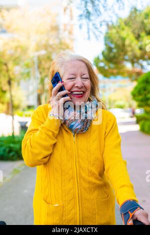 80-jährige Frau, die ein Mobiltelefon benutzt Stockfoto