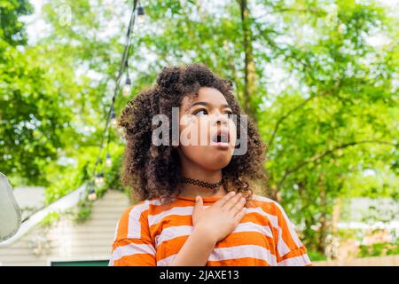 Kind im Hinterhof verhält sich überrascht Stockfoto