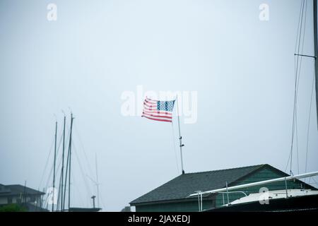 Stock-Fotos von Tropical Storm Elsa aus dem Jahr 2021 Drenching Newport, Rhode Island. Blick auf Regen und amerikanische Flagge auf der Windschutzscheibe während eines Sturms. Stockfoto