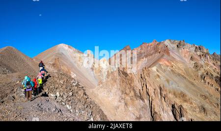 Gruppe von Wanderern, die steinige Berge besteigen Stockfoto