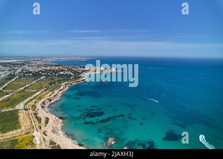 Luftpanoramabo, Drohne aus Sicht der Punta Prima Stadtlandschaft Küste und türkisfarbenes Wasser des Mittelmeers. Costa Blanca, Provinz Alican Stockfoto